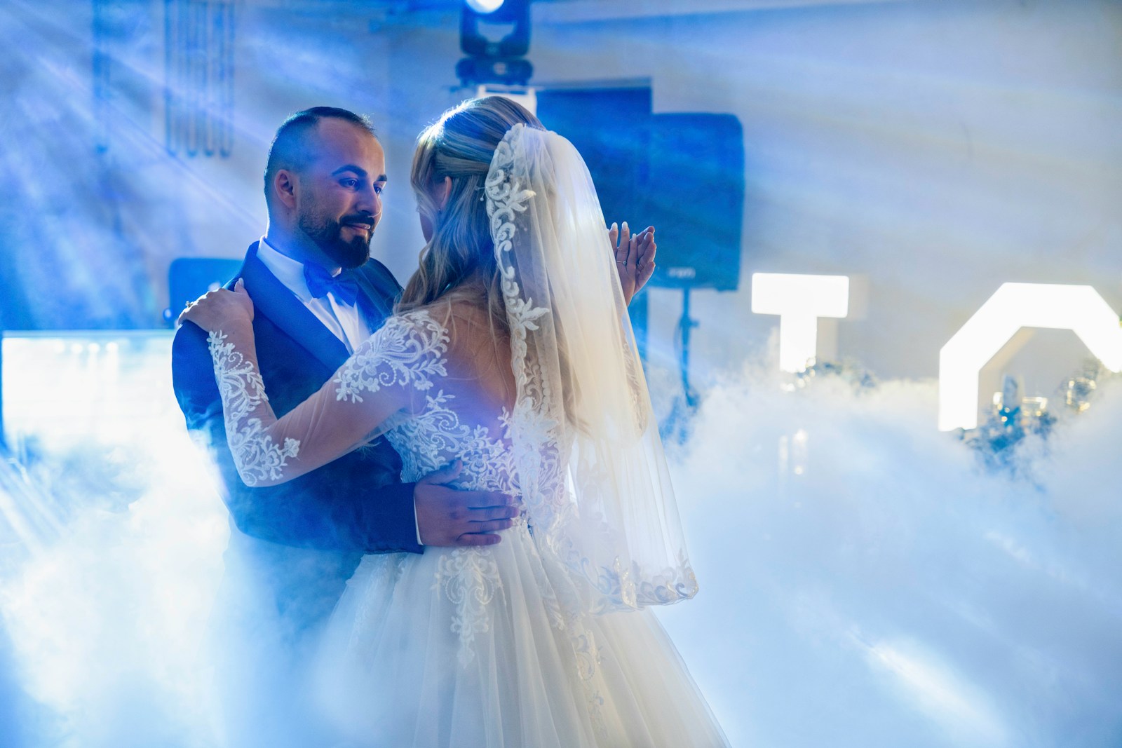 A bride and groom dancing in a cloud of smoke